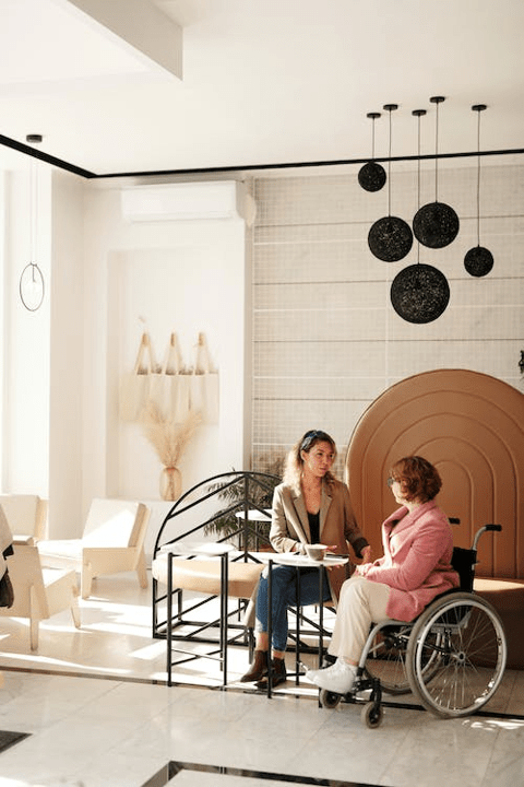 Image of a woman in a wheelchair talking to someone in person 