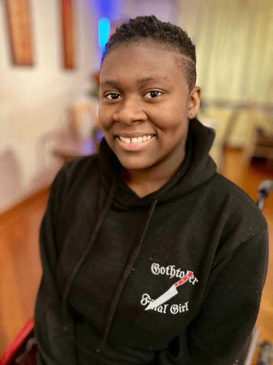 Me in my wheelchair smiling with my hair in a fade cut