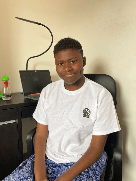 A photo of me facing the camera and smiling with my desk and laptop behind me.